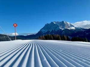 einen schneebedeckten Hang mit einem Berg im Hintergrund in der Unterkunft Das Wetterstein in Ehrwald