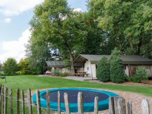 a small pool in a yard next to a house at Atmospheric tent lodge with dishwasher in Twente in Buurse