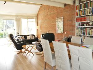 een woonkamer met een tafel en stoelen en een bakstenen muur bij Cosy holiday home in Lauwersoog in Lauwersoog