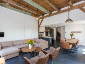 a living room with a couch and tables and chairs at Very luxurious holiday home in beautiful Zeeland style suitable for 7 people in Vrouwenpolder