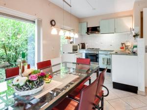 a kitchen with a glass table and red chairs at Holiday Home in Beerze Overijssel with Lush Garden in Beerze