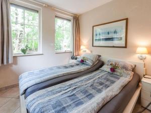 two beds in a bedroom with two windows at Holiday Home in Beerze Overijssel with Lush Garden in Beerze