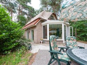 a patio with two chairs and a table and a house at Holiday Home in Beerze Overijssel with Lush Garden in Beerze