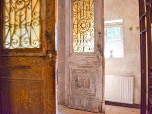 uma porta de madeira antiga num quarto com uma janela em Unique holiday home with a hot tub em Alphen