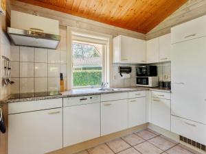 una cucina con armadietti bianchi e una finestra di Luxurious Chalet in Guelders by the Forest a Hulshorst