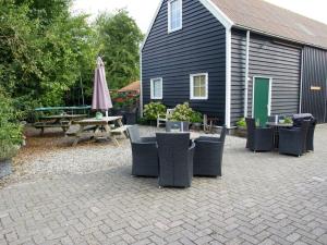 a patio with chairs and a table and an umbrella at Charming Holiday Home near Beach in Meliskerke in Meliskerke