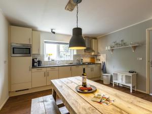 a kitchen with a wooden table with a bottle of wine at Charming Holiday Home near Beach in Meliskerke in Meliskerke