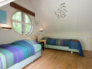 two beds in a room with a window at Tranquil Holiday Home in Dalfsen with Fenced Garden in Dalfsen