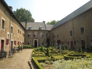un patio de un edificio antiguo con jardín en Located 10km from Maastricht towards the Belgium border, en Eijsden