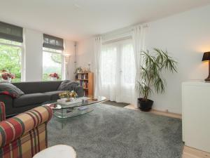 sala de estar con sofá y mesa en Attractive countryside holiday home in quiet, en Schoorl
