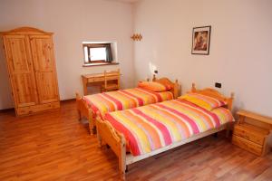 um quarto com 2 camas e piso em madeira em Sentiero Valinis em Fanna