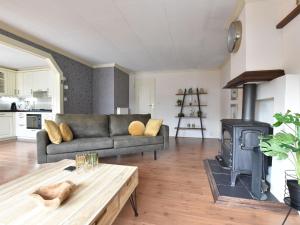 uma sala de estar com um sofá e um fogão a lenha em Modern Holiday Home in Kaatsheuvel with bubble bath em Kaatsheuvel