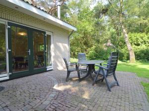 einen Tisch und Stühle auf einer Terrasse in der Unterkunft Comfortable holiday home with a garden in Zelhem