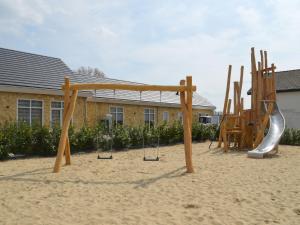 um parque infantil na areia em frente a uma casa em Resort Mooi Bemelen 8 em Bemelen