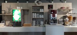 a kitchen with a counter with a coffee machine at Hotel Martinez Grenay in Grenay
