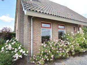 une maison en briques avec des fleurs devant elle dans l'établissement Beautiful Holiday Home in Eede with Garden, à Eede