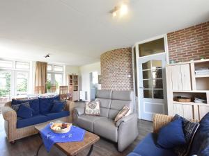 a living room with blue couches and a brick wall at Beautiful Holiday Home in Eede with Garden in Eede