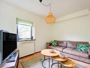 ein Wohnzimmer mit einem Sofa und 2 Tischen in der Unterkunft Lovely Holiday Home in Lunteren near Forest in Lunteren