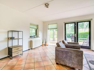 ein Wohnzimmer mit einem Sofa und Fenstern in der Unterkunft Lovely Holiday Home in Lunteren near Forest in Lunteren