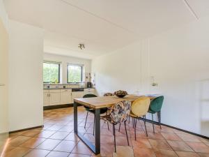 cocina con mesa de madera y sillas en Lovely Holiday Home in Lunteren near Forest, en Lunteren