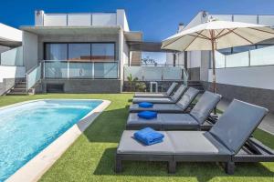 a backyard with a swimming pool and a house at Five Dreams Villas 2 dormitorios piscina privada in Corralejo