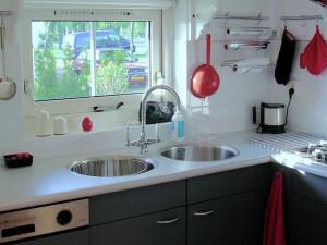 encimera de cocina con 2 lavabos y ventana en Attractive holiday home with jetty, en Steendam