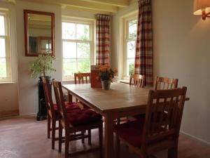 comedor con mesa de madera y sillas en Holiday home in quiet surroundings, en Sintjohannesga