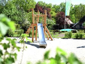 a playground with a slide in the sand at Chalet in Netherlands near Forest & Water in Dalfsen