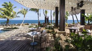 Residences at Dorado Beach, a Ritz Carlton Reserve في دورادو: مطعم على الشاطئ به طاولات وكراسي