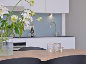 Una mesa de madera con un jarrón de flores encima. en Waterfront Apartment with Terrace, en Kamperland 32 fotos más