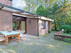 eine Terrasse mit einem Tisch und Stühlen sowie ein Backsteingebäude in der Unterkunft Cozy Holiday Home in Zorgvlied with Private Garden in Zorgvlied