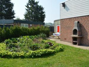 een tuin voor een bakstenen gebouw met een pizzaoven bij Holiday near beach on the Dutch coast in Noordwijkerhout