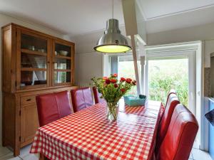 uma mesa de jantar com um vaso de flores em Superb holiday home near the Lauwersmeer em Oostmahorn