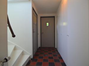 um corredor vazio com uma porta e um piso xadrez em Holiday home in Haaren near the Efteling em Haaren