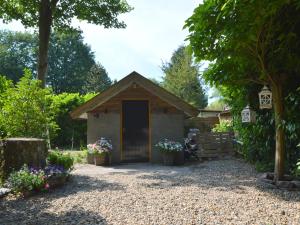 een klein gebouw met een deur in een tuin bij Holiday home in Haaren near the Efteling in Haaren