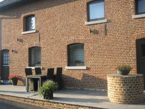 a brick building with a table and chairs in front of it at Elegant Holiday Home in Epen with Fenced Garden in Epen
