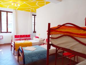 a room with three bunk beds and a yellow ceiling at Ostello S. Fosca - CPU Venice Hostels in Venice