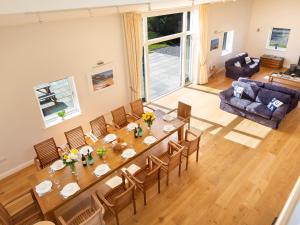 a dining room with a long table and chairs at Moult Hill Barn in Salcombe