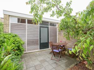 een patio met een tafel en stoelen voor een huis bij Beautiful house in the center of Harlingen in Harlingen