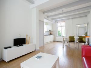 a white living room with a red couch and a table at Beautiful house in the center of Harlingen in Harlingen