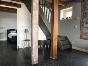 カラントスウオーフにあるQuaint Apartment in Callantsoog with Terraceの階段付きのベッドルーム1室、ベッド1台が備わるベッドルーム1室が備わります。