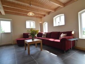 a living room with a red couch and windows at Modern Holiday Home in Holten with Forest Near in Holten