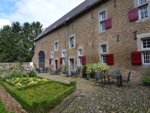 um edifício de tijolos com mesas e cadeiras em frente em Simplistic Villa in Mesch with Garden em Withuis