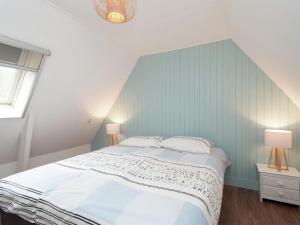 ein Schlafzimmer mit einem großen Bett und zwei Lampen in der Unterkunft Holiday Home in Bergen aan zee with Terrace in Bergen aan Zee