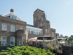 a large brick building with an umbrella in front of it at Holiday Home in Bergen aan zee with Terrace in Bergen aan Zee
