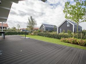 KattendijkeにあるHoliday Home in Kattendijke with Terraceの木製デッキと家屋のある裏庭