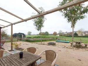 een patio met een tafel en stoelen met een olifant op de achtergrond bij Nice Holiday Home in Horssen at the Farmer with a Garden in Horssen