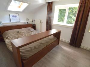 1 dormitorio con cama de madera y ventana en Modern Holiday Home in Haaksbergen with Garden, en Haaksbergen