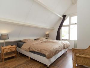 um quarto com uma cama e uma janela em Cosy Holiday Home in Noordwijkerhout near Lake em Noordwijkerhout