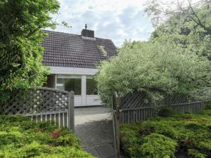uma casa branca com uma cerca de madeira em frente em Cosy Holiday Home in Noordwijkerhout near Lake em Noordwijkerhout